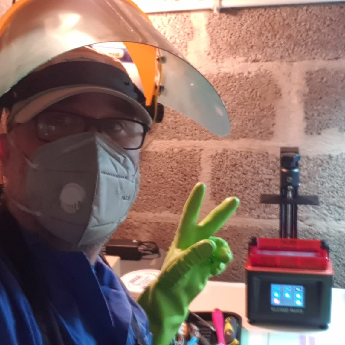 François Lefeuvre équipé d’un masque, de lunettes, d’une visière et de gants dans son atelier